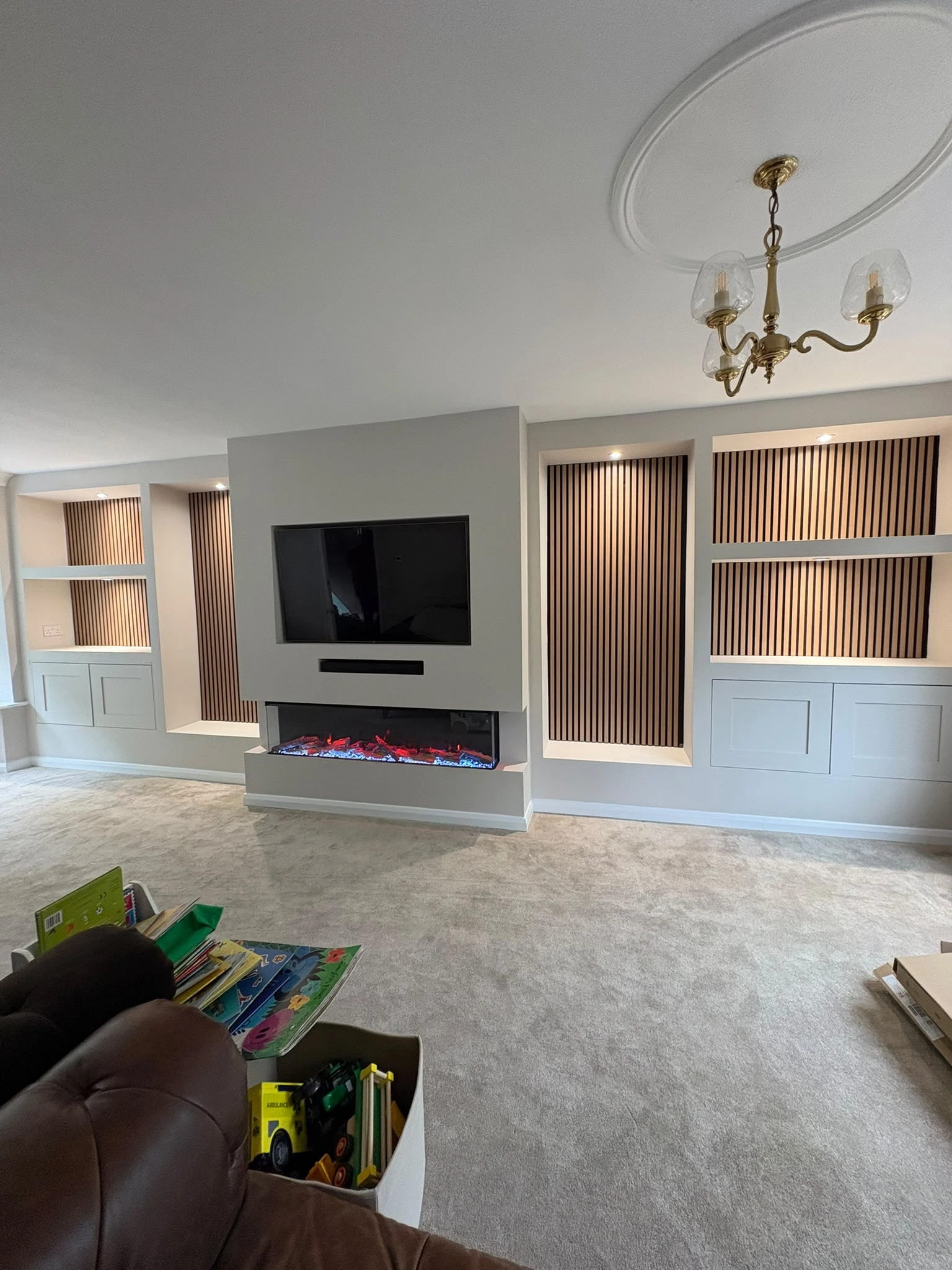 Charcoal Venetian plaster bespoke media wall with custom display shelving and integrated fire